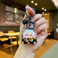 Close-up of creative liquid glitter keychain with cute cartoon figure and black bell - Black Night Light Flashing Quicksand