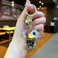 Close-up of a creative astronaut keychain featuring a golden bell and liquid glitter bottle - Lobster Clasp Style / Gold Hardware [Moon] Black Gold Astronaut
