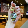 Detailed close-up of astronaut keychain with blue liquid glitter and gold hardware - Lobster Clasp Style / Gold Hardware [Rocket] Black Gold Astronaut