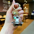 Detail of cute astronaut liquid keychain with UFO pendant and golden bell in hand - Lobster Clasp Style / Gold Hardware [Planet] Black Gold Spaceship