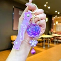 Close-up of purple sakura keychain with liquid sand, flower charm and bell detail - Sakura Strap Purple Luminous Bubble Bead Bell