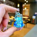 Dettaglio di un ciondolo a forma di unicorno blu con lustrini a stelle e fiocchi - Senza Portachiavi / Blu