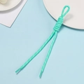 Detail van mintgroen polyester koord met knoop en transparant verzegelde uiteinden - Meergroen met witte stippen