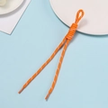 Macro shot of bright orange woven polyester lanyard with spiral knotting and plastic tips - Orange With White Dots