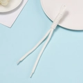 Close-up of white handmade woven cord with precise knots and clear plastic aglets - White