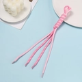 Detail of pink woven cords with plastic aglets on a blue background with decor - Pink Color Block