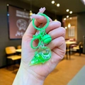 Macro detail of a green liquid ice cream keychain with sequins and a matching bell - Green Sparkling