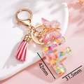 Dettaglio portachiavi lettera F in resina rosa con cuori glitterati e dimensioni - F Rosa