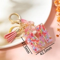 Dettaglio portachiavi lettera M in resina con paillettes, nappa rosa e farfalla - Rosa M