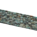 Vue macro de perles cylindriques en pierre naturelle turquoise pour bijoux DIY - 1 Fil (env. 85 perles) / Pierre de pin africaine