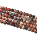Macro detail of natural red fire agate beads with unique circular patterns and polished finish - 1 Strand Approx 60 Pcs (6-6.5mm) / Orange Brown Flame Agate