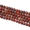 Macro detail of polished natural red jasper round beads for DIY jewelry making - Red Tiger Skin Agate