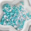 Macro view of mixed Tiffany blue and white acrylic beads in a white petal-shaped tray - Light Blue Series