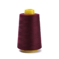 Detail of dark red polyester sewing thread on a yellow plastic cone for garment making - Approx 100g / Burgundy