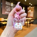 Primo piano di un portachiavi a forma di gatto rosa con guscio trasparente e campanello - Stile Chiusura a Moschettone / Volpe con Perline a Bolle Luminose