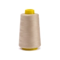 Close-up of beige 402 polyester sewing thread on a yellow cone for garment stitching - Approx 100g / Light Coffee