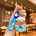 Gros plan d'un porte-clés Cinnamoroll avec lanière bleue et anneau de beignet coloré - Corde À Fraises [big Bait Dog] Donut En Pvc Phosphorescent