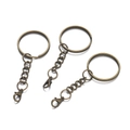 Three bronze metal keychains with split rings, chains, and lobster clasps on white background - Bronze