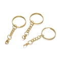 Close-up of golden keychain rings with lobster clasps and link chains for DIY crafts - Gold