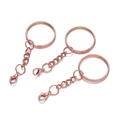 Close-up of three rose gold lobster clasp keychains with flat rings and link chains - Rose Gold