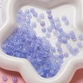 Gros plan de perles lavande translucides dans un plateau en étoile pour bijoux DIY - Perle Rondelle en Verre (AC4486) / Pack de 100 / Bleu-violet / 3*6.5mm
