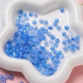 Gros plan de perles d'abaque bleues translucides dans un plateau floral pour bijoux DIY - Perle Rondelle en Verre (AC4486) / Pack de 100 / Bleu / 3*6.5mm