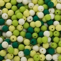 Macro detail of 6mm mixed green acrylic beads with matte texture for DIY jewelry making - Green System