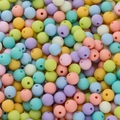 Macro view of assorted 6mm matte macaron acrylic beads with smooth central holes - Macaron Series