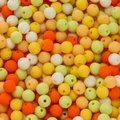 Macro detail of 6mm matte acrylic beads in mixed warm colors for DIY jewelry making - Orange Yellow Series