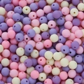 Macro shot of 6mm matte pastel acrylic beads in pink, lavender, and white for DIY jewelry - Pink and Purple Series