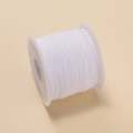 Nahaufnahme von 0,6mm weißer Nylonschnur auf Kunststoffspule für DIY-Schmuckarbeiten - Weiß