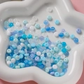 Nahaufnahme von 3x6mm blau-weißen Glasperlen in einer sternförmigen Schale - 50 Stück Packung ca. 11g / Blau-Serie