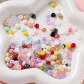 Gros plan de perles en verre colorées 3x6mm pour bijoux DIY dans un plateau blanc - Mélange Aléatoire