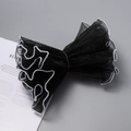 Detail of black wavy mesh cuffs with white pearl edges for elegant gift packaging - Black Double Pearl Edge