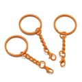 Detailansicht von drei orange lackierten Metall-Karabinerverschlüssen und Schlüsselringen - Orange