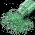 Macro detail of iridescent light green glass shards falling from a 30g plastic bottle - Verdant / 30ml Bottle