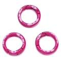 Detailopname van drie magenta geëmailleerde ronde veerringen met paarse stippen - Rozerood