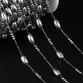 Macro shot of silver stainless steel beaded oval chain on reel for DIY jewelry making - Approx 5*8.5mm Oval, 1 Meter / Steel