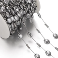 Macro view of gunmetal oval bead chain on a white reel for DIY jewelry making - Approx 6*7.5mm Oval, 1 Meter / Steel