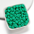 Macro detail of 8mm light green acrylic donut beads in a white square tray for DIY jewelry - 50 Pieces/Pack (4.5x8mm) / Green