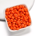 Macro view of bright orange acrylic donut beads for DIY necklace and bracelet jewelry - 50 Pieces/Pack (4.5x8mm) / Orange