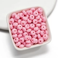 Macro detail of 8mm pink acrylic donut beads for DIY jewelry making and necklaces - 50 Pieces/Pack (4.5x8mm) / Pink