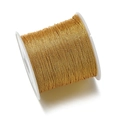 Primer plano de un carrete de hilo de poliéster dorado para tejido de joyas y bordado - Dorado