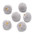 Macro shot of fluffy grey faux mink fur pom-pom pendants with gold metal rings for DIY jewelry - Gray