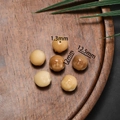 Detailed macro of hand-carved Bodhi root Buddha head beads with 1.3mm hole size - Buddha Head Style / Approx 12x12.5mm