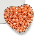 Macro shot of orange AB coated acrylic beads with pearlescent finish in a heart-shaped tray - 6mm (100 Pieces/Pack) / Gold