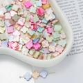 Close-up of colorful clover-shaped shell beads for DIY jewelry in a ceramic tray - Four-Leaf Clover Style (AC4106) / 1 Strand (approx. 38 pcs, 10x10mm)