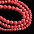 Macro detail of red and pink striped agate beads with marble texture in various sizes - Approx. 6.5mm (64 Pcs/Strand) / Red Stripes