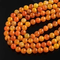 Macro shot of orange dragon vein agate beads with natural ice crack texture and glossy finish - Orange Yellow Dragon Vein Agate