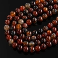 Macro shot of 8-10mm red dragon vein agate beads with polished texture and natural patterns - Dream Agate